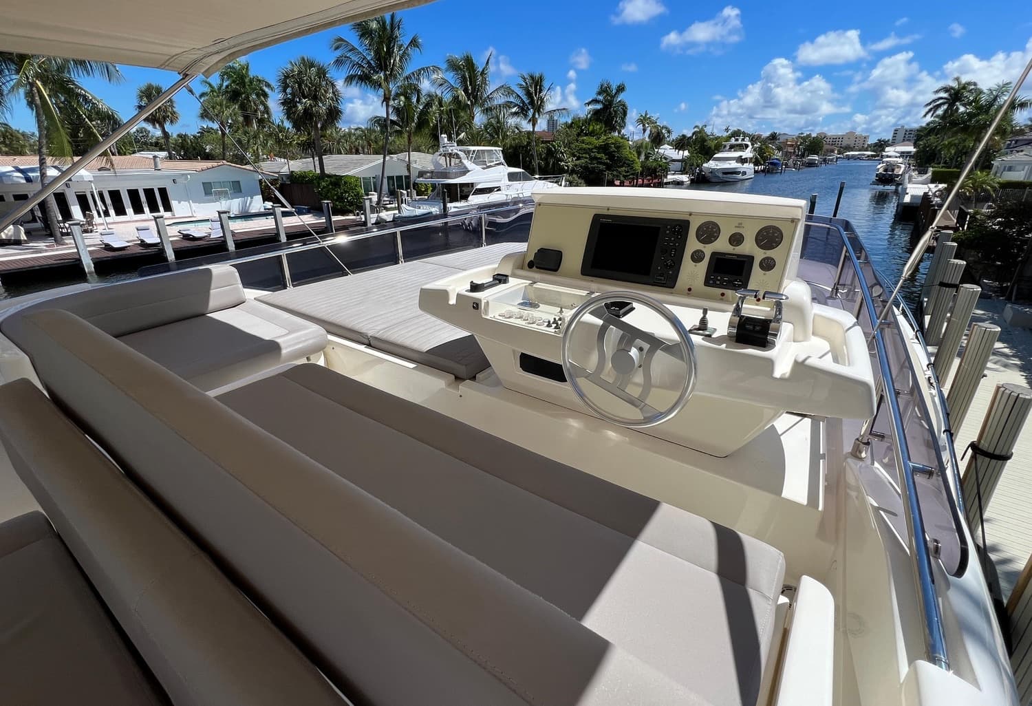 The flybridge helm and lounge under a full-length canopy.