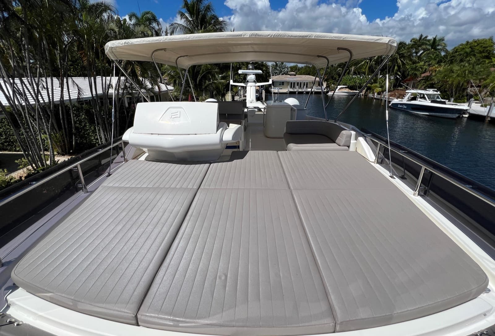 Wide foredeck sun pads beneath the flybridge canopy.