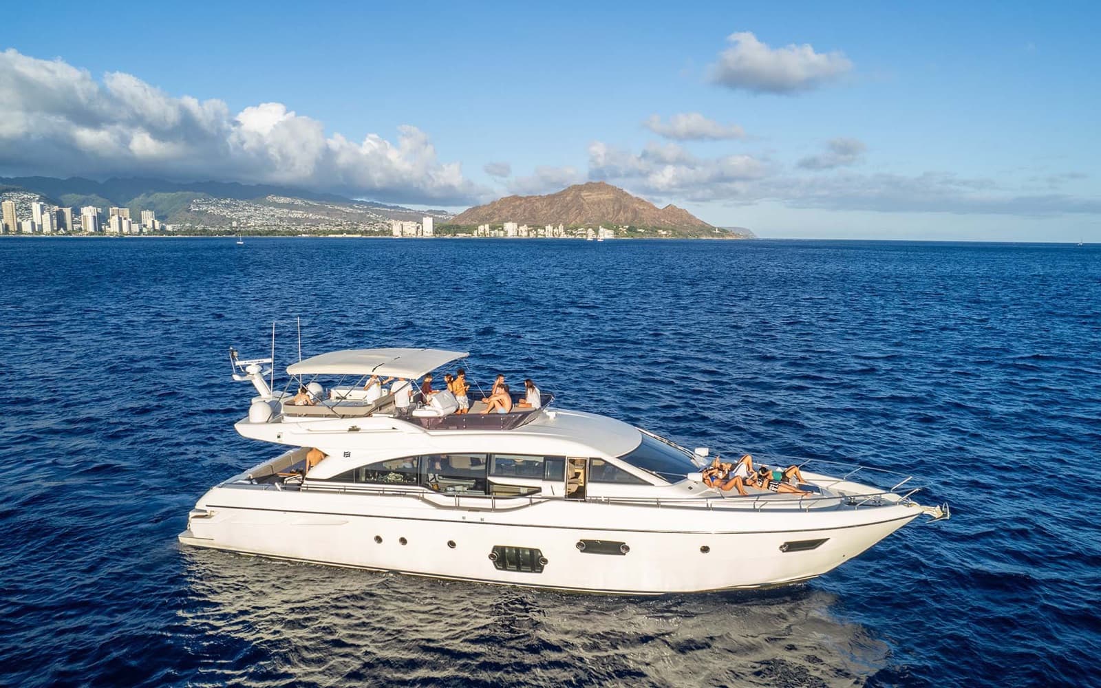 The Alana Kai, a 69-foot Ferretti motor yacht, cruising off Diamond Head with guests aboard.